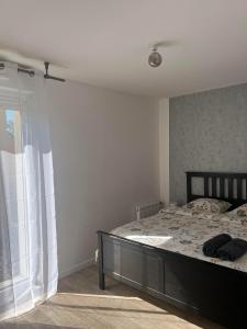 1 dormitorio con cama y ventana en Appartement rez de chaussée avec parking privé, en Orléans