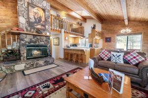 een woonkamer met een bank en een open haard bij Lakeview Haven - Large cabin with game room close to the lake! in Big Bear Lake