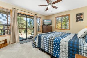 een slaapkamer met een bed en een plafondventilator bij Lakeview Haven - Large cabin with game room close to the lake! in Big Bear Lake