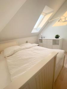 a white bed in a room with a window at Wattwürmchen in Wremen