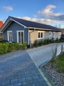 a house with a brick driveway in front of it at Ferienhaus Seehuis, Sauna, angeln, familienfreundlich in Twist