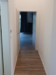 a hallway with white walls and a wooden floor at Ferienhaus Seehuis, Sauna, angeln, familienfreundlich in Twist