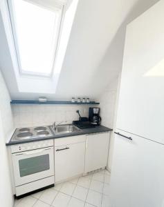 Una cocina con estufa, fregadero y ventana. en Wattwürmchen, en Wremen 15 fotos más