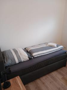 a bed sitting in a room next to a wall at Ferienhaus Seehuis, Sauna, angeln, familienfreundlich in Twist