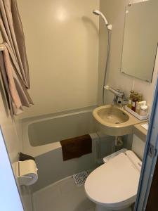 a small bathroom with a toilet and a sink at A private retreat Cotton Club Cottage in Takamori