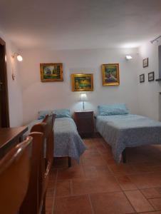 Mulazzo的住宿－la casa nel bosco，一间设有两张床和一张桌子及椅子的房间