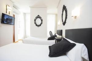 - 2 lits dans une chambre avec 2 miroirs sur le mur dans l'établissement Hotel Valencia de la Música, à Valence 24 autres photos