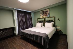 a bedroom with a large bed with two pillows at Paliani Hotel in Mestia