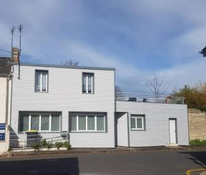 a large white house with at Maison Bateau in Lion-sur-Mer