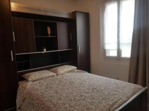 um quarto com uma cama grande e uma janela em Maison Bateau em Lion-sur-Mer