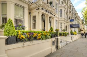 a building with flowers on a street at City Continental London Kensington in London