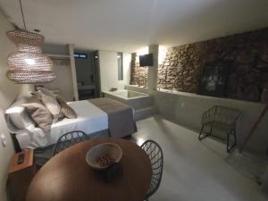 Cette chambre comprend un lit, une table et une télévision. dans l'établissement Casa Oyá, à Morro de São Paulo