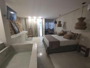 1 dormitorio con 1 cama grande y bañera en Casa Oyá en Morro de São Paulo