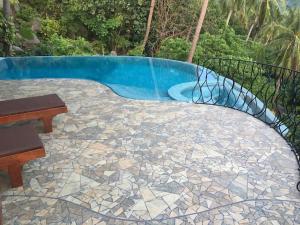 une terrasse avec une piscine, une table et un banc dans l'établissement Monkey Flower Villas, à Koh Tao