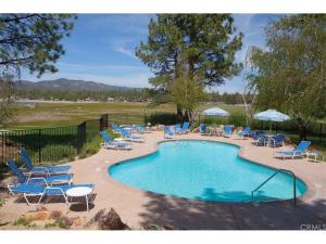 a swimming pool with lounge chairs and a bunch ofitures at Junipine Lakefront Condo - Walking distance to the lake! Less than 2 miles from the slopes! in Big Bear Lake