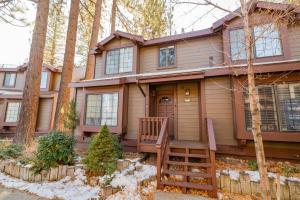 a house in the woods with a porch at Junipine Lakefront Condo - Walking distance to the lake! Less than 2 miles from the slopes! in Big Bear Lake