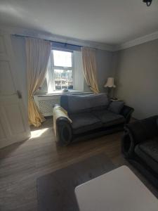 Un dormitorio con una cama y un sofá y una ventana. en Appletree lodge, en Dungiven