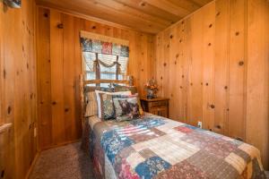 - une chambre avec des murs en bois et un lit dans un dortoir dans l'établissement Cozy on Rainbow - Delightful property in a quite residential area! Perfect mountain getaway!, à Big Bear City