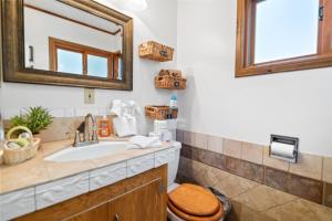 La salle de bains est pourvue d'un lavabo, de toilettes et d'un miroir. dans l'établissement Cozy on Rainbow - Delightful property in a quite residential area! Perfect mountain getaway!, à Big Bear City