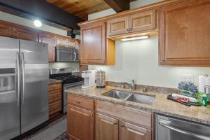 a kitchen with wooden cabinets and a stainless steel refrigerator at KCs Haven - Relax with the whole family at this peaceful cabin in Sugarloaf