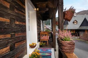 a porch of a log cabin with flowers in a basket at Chalupa Bocza in Nižná Boca