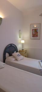 een slaapkamer met 2 bedden en een lamp op een tafel bij Villetta Rocchi - Costa Paradiso in Costa Paradiso