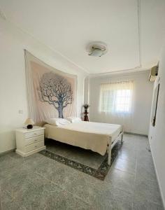 a bedroom with a bed and a tree painting on the wall at Alma Rustica in Albufeira