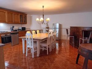 a kitchen with a table and chairs and a refrigerator at Alma Rustica in Albufeira