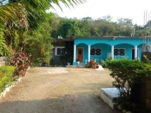 a blue house in the middle of a yard at The Gibson's Palace in Ocho Rios