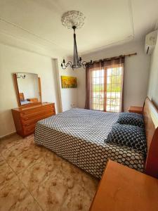 a bedroom with a bed and a mirror and a chandelier at Alma Rustica in Albufeira