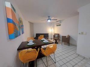 a living room with a table and yellow chairs at Villas Cozumel #9 in Cozumel
