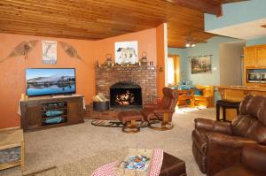 a living room with a television and a fireplace at Coy Cottage - NEAR OKTOBERFEST! Calm & quite location within minuets of the heart of town! in Big Bear City
