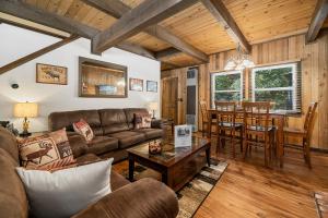 a living room with a couch and a table at Little Bear Cottage - Cozy, quaint cabin with a great fireplace and so many fun board games! in Big Bear Lake