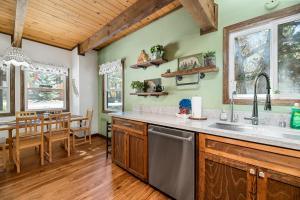 a kitchen with green walls and a wooden ceiling at Little Bear Cottage - Cozy, quaint cabin with a great fireplace and so many fun board games! in Big Bear Lake +17 photos