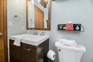 a bathroom with a sink and a toilet and a mirror at Little Bear Cottage - Cozy, quaint cabin with a great fireplace and so many fun board games! in Big Bear Lake