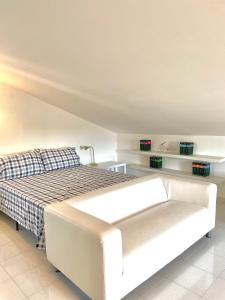 - une chambre avec un lit blanc et un canapé dans l'établissement Villa Valentina, à Treglio