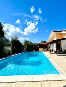 une grande piscine bleue à côté d'une maison dans l'établissement Villa Valentina, à Treglio
