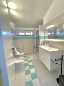 La salle de bains est pourvue de 2 toilettes, d'un lavabo et d'un miroir. dans l'établissement Villa Valentina, à Treglio