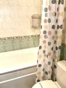 uma casa de banho com uma banheira, um WC e uma cortina de chuveiro. em Apartment Marina beach k-s Triumph em Sveti Vlas
