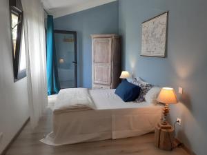 a bedroom with a bed with blue walls and a window at Mas en Provence calme et sérénité piscine chaufffée in Verquières