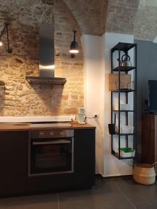 a kitchen with a stove top oven next to a wall at Urban79 in Bernalda