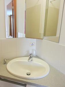 ein Waschbecken im Bad mit Spiegel in der Unterkunft Orange Wings Wiener Neustadt in Wiener Neustadt