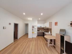 a kitchen with white walls and a wooden floor at Apartman Tailor in Liptovský Mikuláš