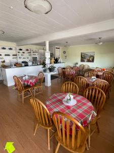 a restaurant with tables and chairs and a kitchen at Winsome Inn in Saint Stephen
