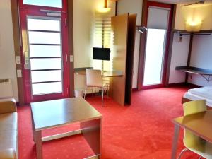 Habitación de hotel con cama y escritorio en Orange Wings Wiener Neustadt, en Wiener Neustadt