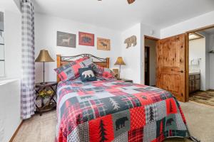 een slaapkamer met een bed met een kerstsprei bij Edventures Await - Beautifully updated mountain home with billiards and hot tub! in Big Bear Lake