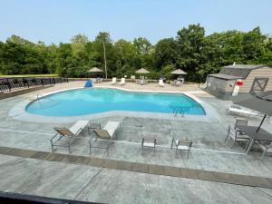 una gran piscina con mesas y sillas. en Country Inn & Suites by Radisson, Erlanger, KY en Erlanger