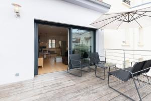 eine Terrasse mit Stühlen, einem Tisch und einem Sonnenschirm in der Unterkunft La Terrasse Du Gibet in Montigny-lès-Metz