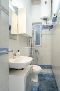 a white bathroom with a sink and a toilet at Marina View in Limenas +39 photos