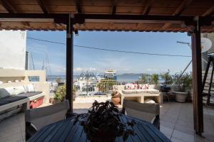 een patio met een tafel en stoelen en uitzicht op het water bij Marina View in Limenas